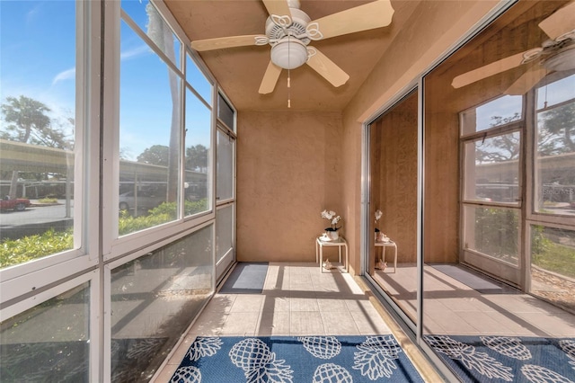 unfurnished sunroom featuring ceiling fan