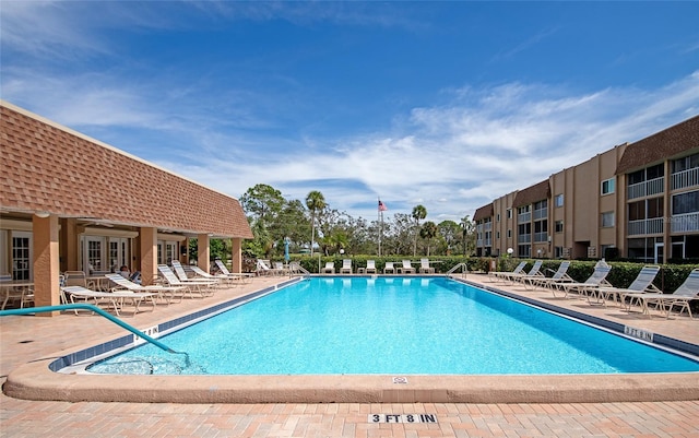 view of swimming pool featuring french doors and a patio area