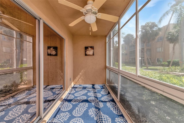 unfurnished sunroom with ceiling fan