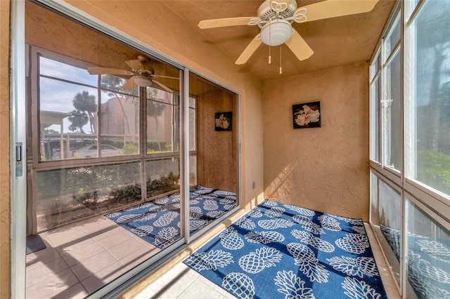 unfurnished sunroom with ceiling fan