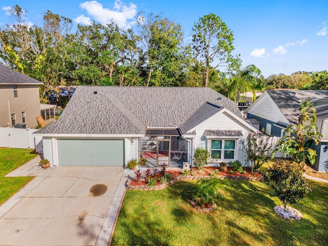 view of front of property with a lanai, a front yard, and a garage