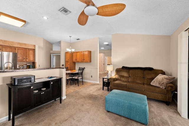 carpeted living room featuring a textured ceiling, vaulted ceiling, and ceiling fan with notable chandelier