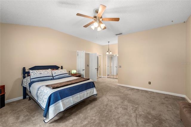 carpeted bedroom with ceiling fan with notable chandelier, a textured ceiling, and vaulted ceiling