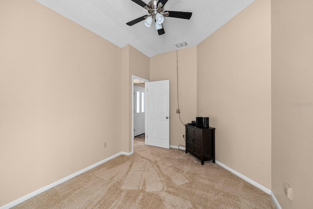 unfurnished bedroom with ceiling fan, lofted ceiling, light carpet, and a textured ceiling