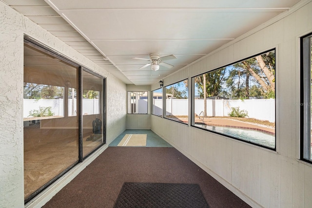 unfurnished sunroom featuring ceiling fan