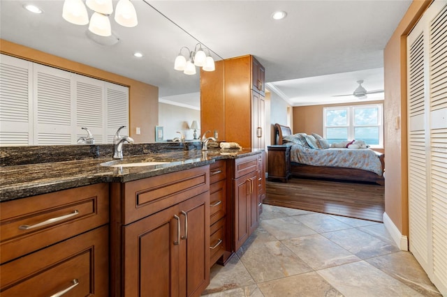 interior space featuring vanity, ornamental molding, ceiling fan with notable chandelier, and hardwood / wood-style floors