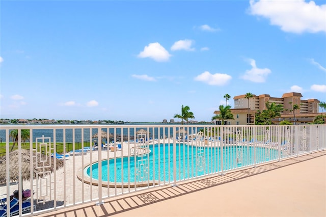 view of pool with a water view and a patio area