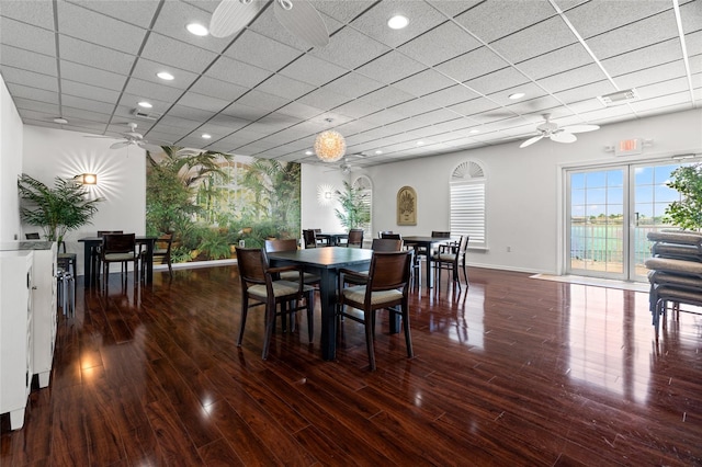 dining space with a drop ceiling, dark hardwood / wood-style floors, and ceiling fan