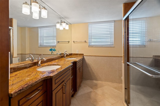 5200 Brittany Dr S Unit 1202, Saint Petersburg, FL 33715 - full bathroom with double vanity, tile walls, a shower stall, wainscoting, and tile patterned flooring