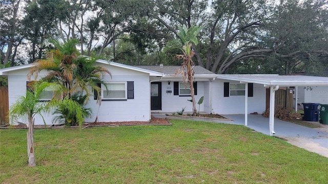 ranch-style home featuring a front lawn and a carport