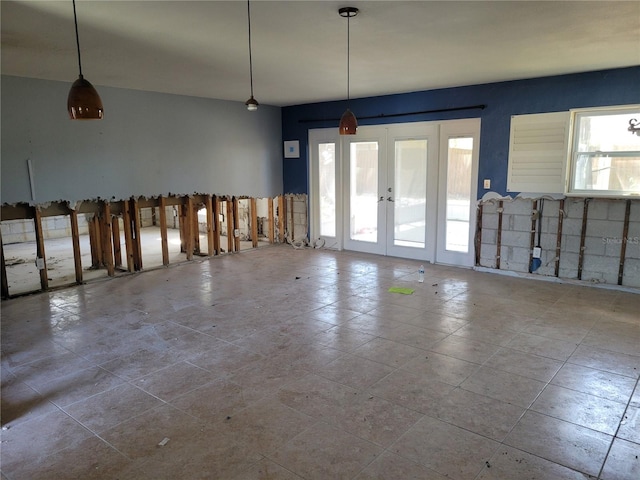 unfurnished room with french doors and a healthy amount of sunlight