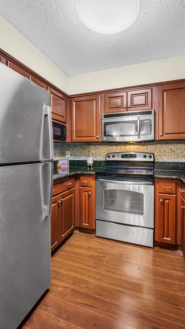 kitchen featuring appliances with stainless steel finishes, dark hardwood / wood-style floors, and tasteful backsplash