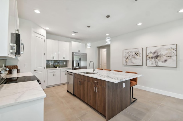 kitchen featuring white cabinetry, stainless steel appliances, dark brown cabinets, and sink