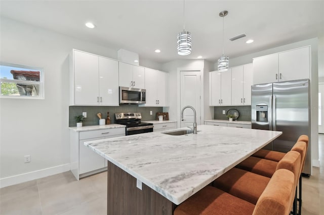 kitchen featuring sink, appliances with stainless steel finishes, decorative backsplash, and white cabinets