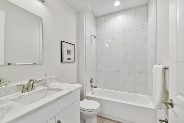 full bathroom featuring toilet, tiled shower / bath, and vanity