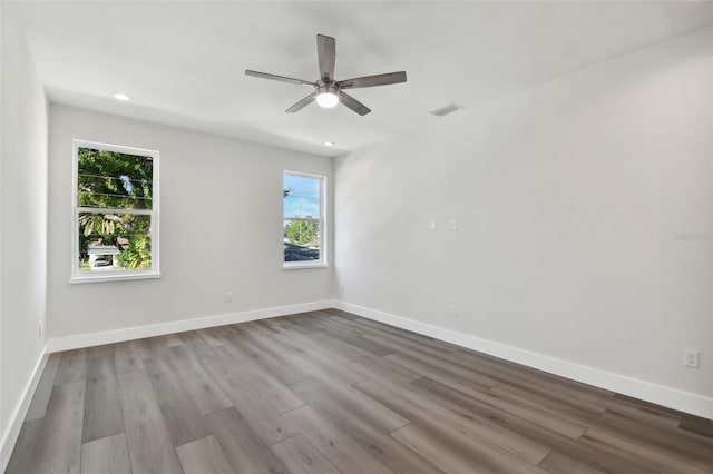 empty room with ceiling fan, light hardwood / wood-style flooring, and plenty of natural light