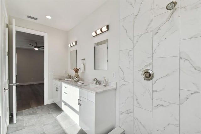 bathroom with vanity, a tile shower, and ceiling fan