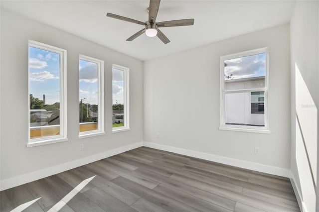 empty room with hardwood / wood-style floors and ceiling fan