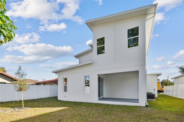 back of property featuring a lawn and central AC unit