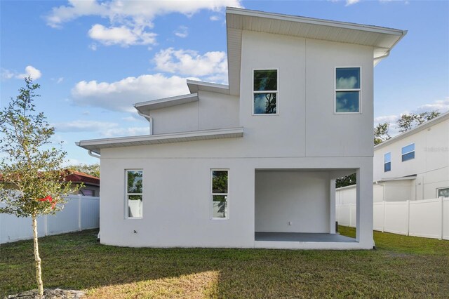 back of house featuring a lawn