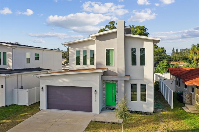 contemporary house featuring a front yard and a garage