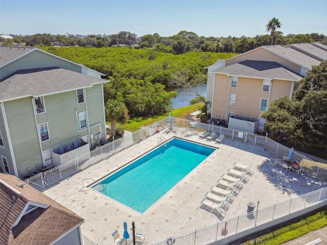 view of swimming pool featuring a patio and a water view