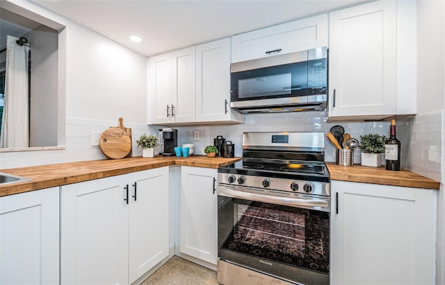 kitchen featuring white cabinets, wooden counters, and stainless steel appliances