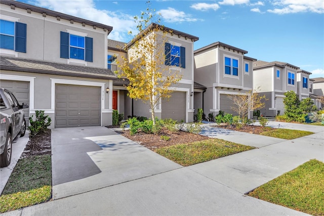 view of front of home with an attached garage, concrete driveway, and stucco siding