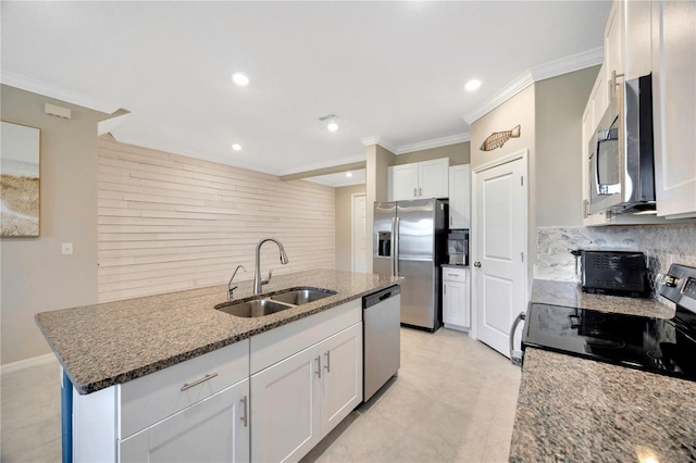 kitchen featuring appliances with stainless steel finishes, sink, a kitchen island with sink, and white cabinetry