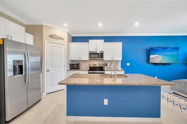 kitchen with sink, appliances with stainless steel finishes, white cabinets, and an island with sink