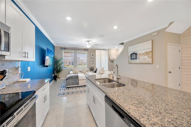 kitchen featuring stainless steel appliances, crown molding, sink, white cabinetry, and light stone counters