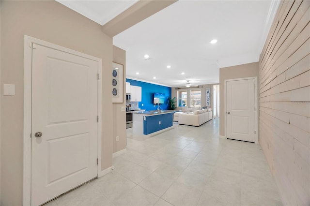 tiled living room with ornamental molding and ceiling fan