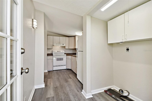 kitchen with light hardwood / wood-style floors, vaulted ceiling, and white appliances