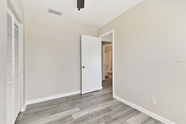 unfurnished bedroom with a closet, hardwood / wood-style floors, and ceiling fan