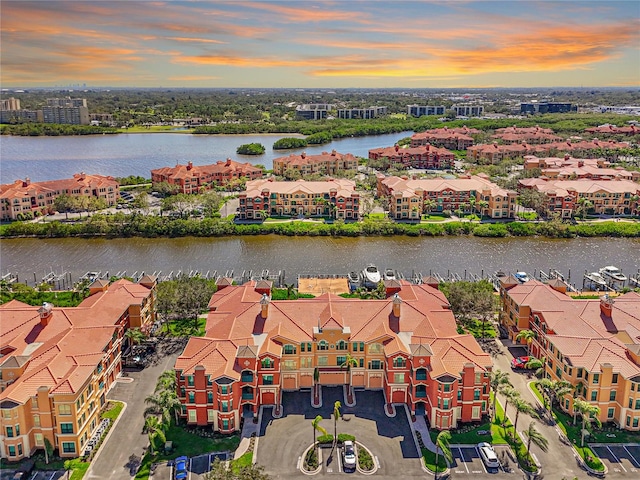 aerial view at dusk featuring a water view