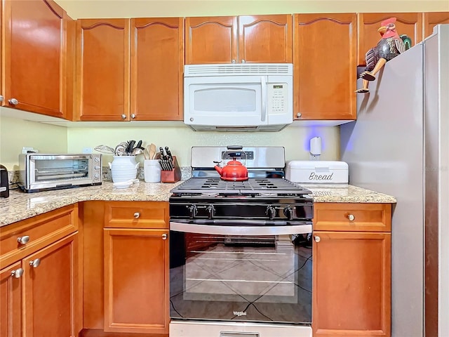 kitchen with light stone countertops and stainless steel appliances