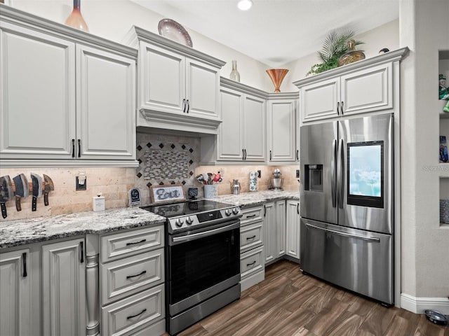 kitchen with backsplash, dark wood-type flooring, extractor fan, and appliances with stainless steel finishes