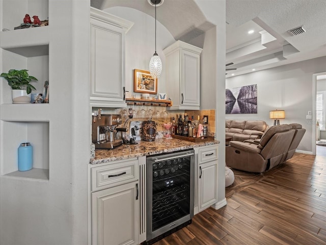 bar with decorative light fixtures, white cabinetry, wine cooler, a raised ceiling, and dark wood-type flooring