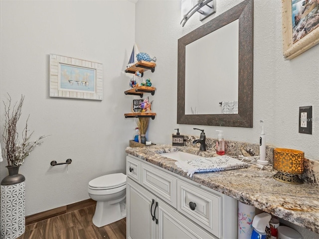 bathroom featuring vanity, hardwood / wood-style floors, and toilet