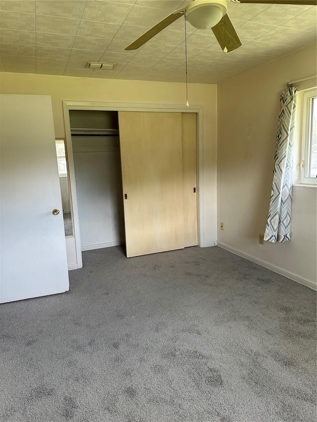 unfurnished bedroom featuring carpet flooring, a closet, and ceiling fan