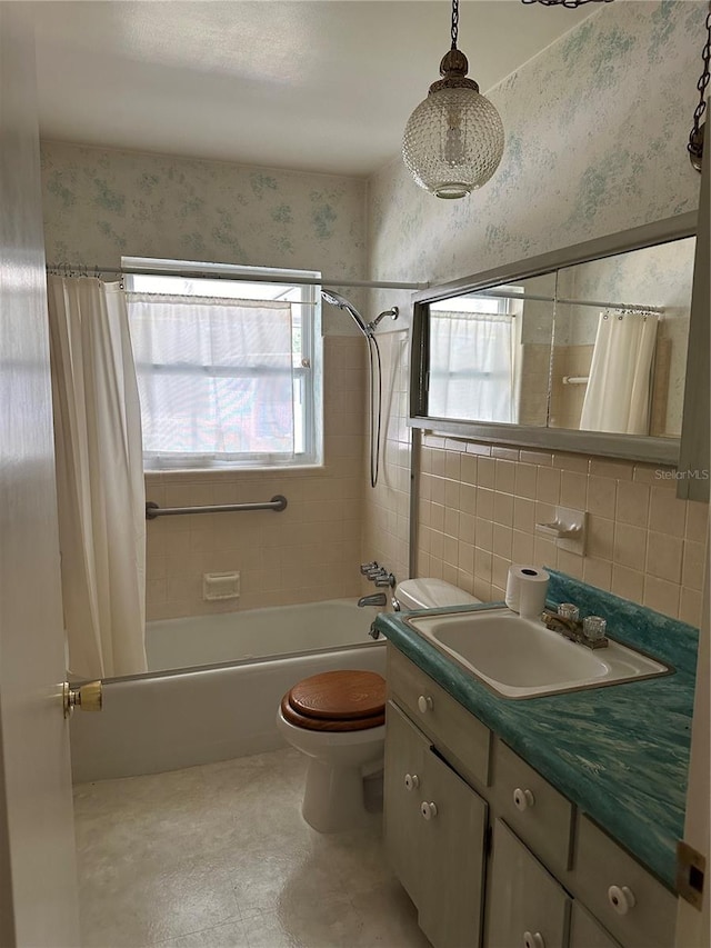 full bathroom with vanity, toilet, tile walls, and shower / tub combo with curtain