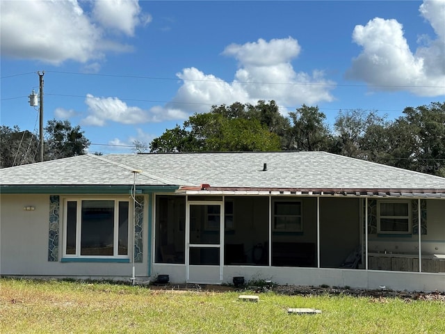 rear view of house with a lawn and a sunroom