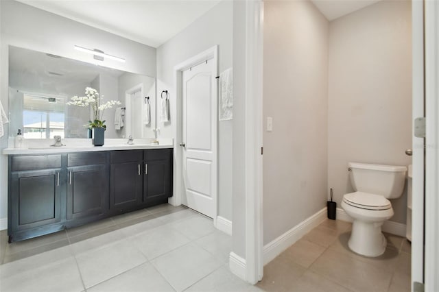 bathroom featuring tile patterned flooring, vanity, and toilet