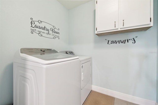 laundry area featuring separate washer and dryer and cabinets