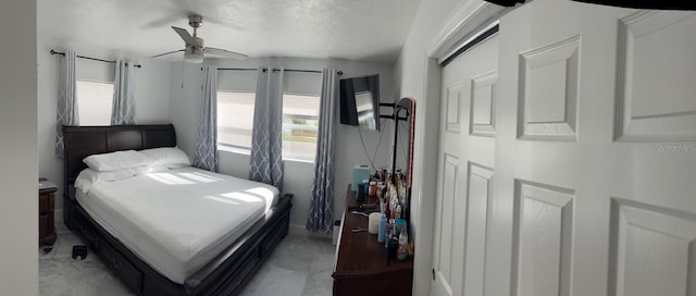 bedroom featuring ceiling fan and a textured ceiling