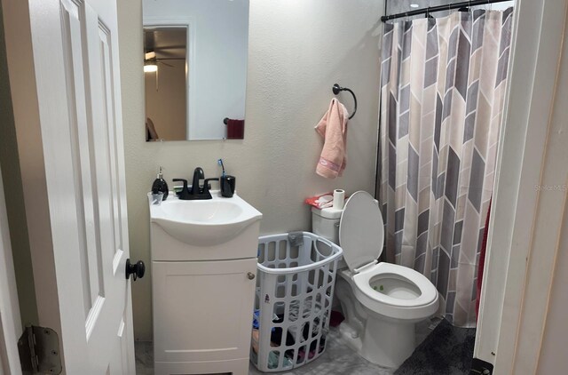 bathroom with walk in shower, vanity, and toilet