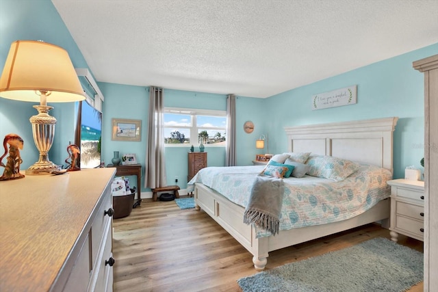 bedroom featuring a textured ceiling and light wood-type flooring