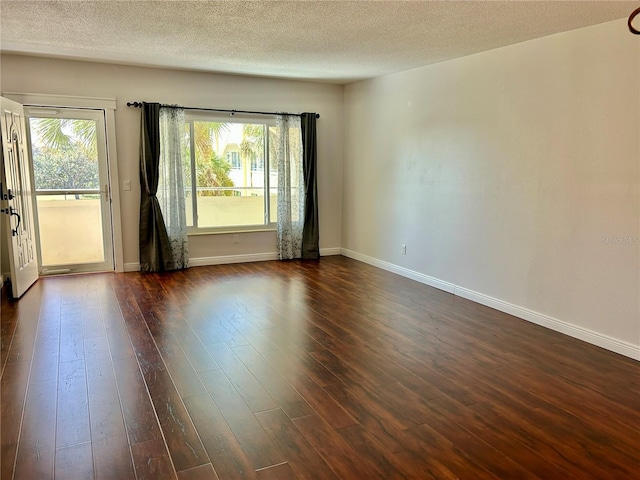 unfurnished room featuring a textured ceiling, a wealth of natural light, and dark hardwood / wood-style floors