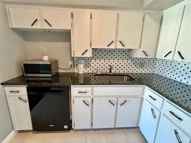 kitchen with tasteful backsplash, sink, dishwasher, dark stone counters, and light tile patterned floors