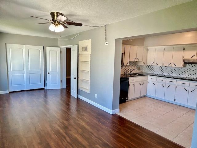 kitchen with light hardwood / wood-style floors, white cabinets, ceiling fan, and backsplash